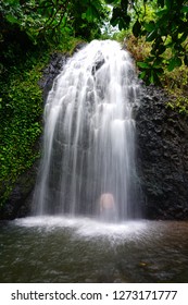 View Of The Silhouette Of A Man Bathing Under A Cascading Waterfall In Tahiti, French Polynesia