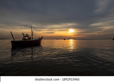 The view of the sky after sunset is beautiful with the reflection of the fishing boat in the sea in Thailand. - Powered by Shutterstock