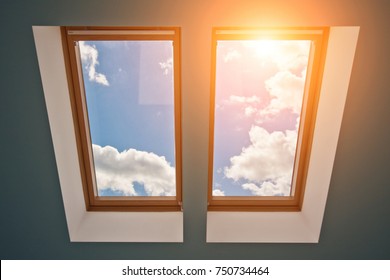 View of the sky and clouds from the window on the roof, sunlight through the attic window, light in the house, skylights 
