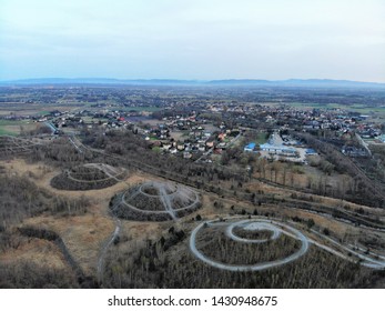 A view from the sky to mining heaps and a mountain range on the horizon.