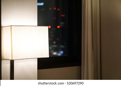 View of skyscrapers outside the window of a modern hotel room at night 
