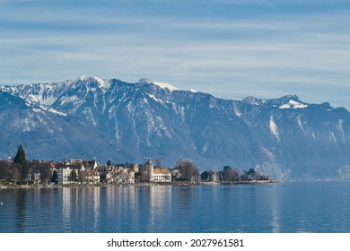 View of small town La Tour-de-Peilz in Vaud, Switzerland, from Lac leman shore, with Swiss alps on the back