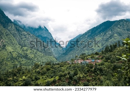 The view of a small town surrounded by green mountains. Kasol, India.
