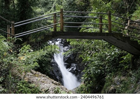 View of small waterfall and a bridge on cloudy day. Aling-Aling waterfall, Bali, Indonesia.