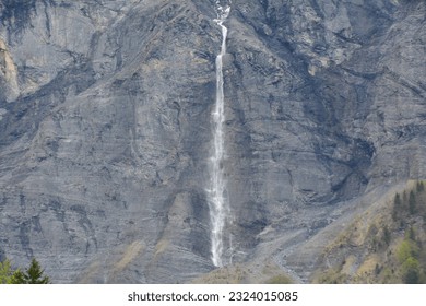 VIEW OF A SMALL WATERFALL IN THE MOUNTAIN