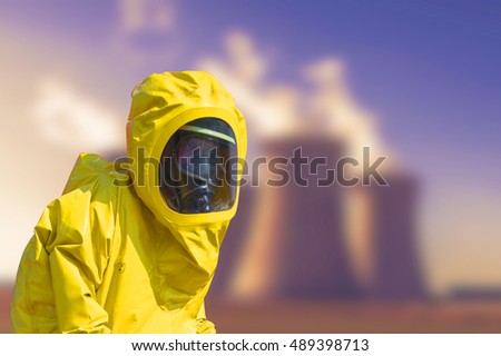 View of smoking coal power plant and men in protective hazmat suit
