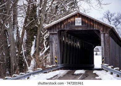 A View Of A Snow Covered McCafferty Covered Howe Through Truss Bridge In Ohio.