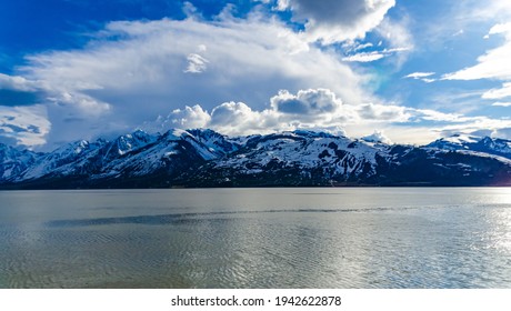 View of the snow-capped mountains in the clouds near the lake Gren Titon, USA - Powered by Shutterstock