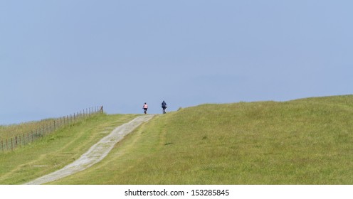 View From The South Downs Way Footpath, Sussex, England Uk - Fit Senior Couple Cycling Up A Hill On Mountain Bikes