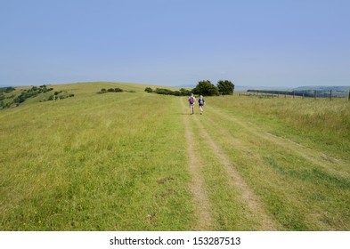 View From The South Downs Way Footpath, Sussex, England Uk - Fit Senior Couple Walking On Footpath