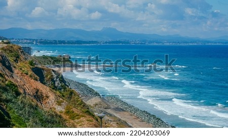 a view of the southernmost side of the Cote des Basques Beach in Biarritz, France, and the Marbella Beach and its breakwater in the background