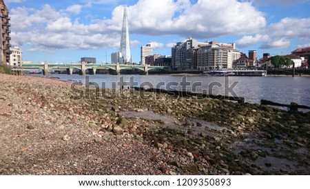 View of Southwark Bridge and the Shard from the Thames foreshore at Millenium Bridge, London