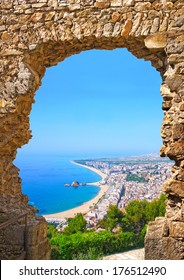 View Of Spanish Beach Through A Stone Door Of The St. John Castle Of Resort Town Blanes In Summertime. Costa Brava, Catalonia, Spain