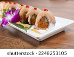 A view of a spicy albacore tuna roll, featuring escolar and cucumber, 