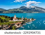 View of Spiez Church and town on the shore of Lake Thun in the Swiss canton of Bern at sunset, Spiez, Switzerland. Spiez city on lake Thun in the canton of Bern, Switzerland.