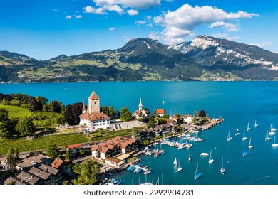 View of Spiez Church and town on the shore of Lake Thun in the Swiss canton of Bern at sunset, Spiez, Switzerland. Spiez city on lake Thun in the canton of Bern, Switzerland.