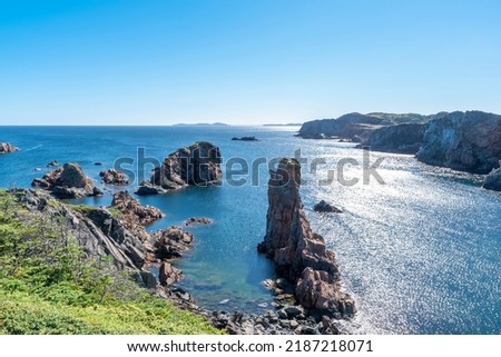 A view of Spiller's Cove near Twillingate, Newfoundland, as seen from the top of one of the cliffs surrounding it, on a beautiful sunny day.