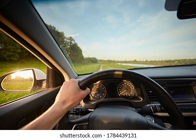 View Of The Spring Field Road From Inside Car In The Windshield. Man's Hands Drive Vehicles 