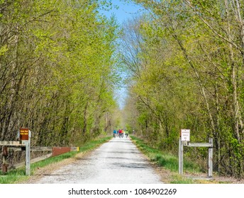 View Of The Spring Trail In A Missouri State Park; Tiny Figures Of Bicyclists In The Background; Spring In The Midwest