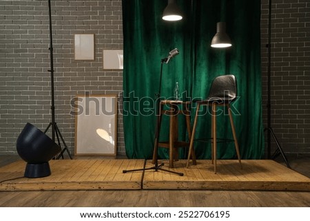 View of standup scene with stool, microphone and glowing lamps