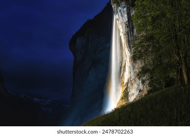 the view of staubbach waterfall at night when it is illuminated. Famous landmark in Lauterbrunnen, Switzerland