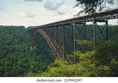 A view of the steel metal arch bridge over the New River Gorge in Fayetteville, West Virginia.  The bridge is the longest steel span in the western hemisphere.  Repeating lines.  Horizontal image. - Shutterstock ID 1179952297
