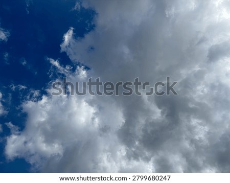 A view of storm clouds forming, where scattered light pierces the threatening darkness.