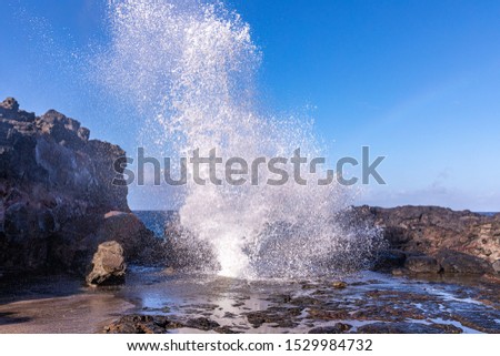 View at a stream of water and steam exploding from Nakalee blowhole, Maui, Hawaii