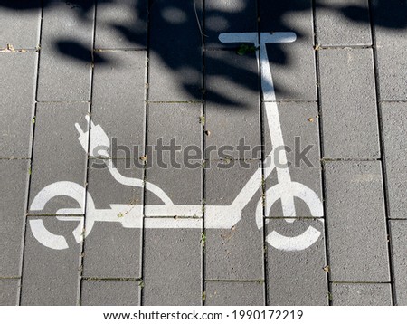 A view of a street. Electric scooter charging station, symbol on the street.