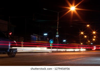 The View Of The Strip Of Light From The Car Headlights That Pass On The Road, Which Has A Lamp Installed To Illuminate The Side Of The Street At Night.