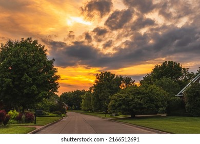 View Of Suburban Midwestern  Neighborhood At Sunset In Summer; Dramatic Sky In Background
