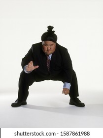 View Of A Sumo Wrestler In A Business Suit Squatting