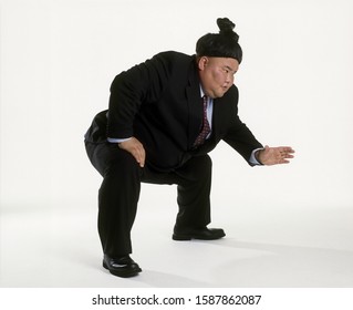 View Of A Sumo Wrestler In A Business Suit Squatting