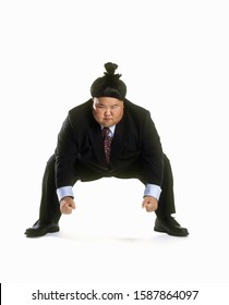 View Of A Sumo Wrestler In A Business Suit Squatting