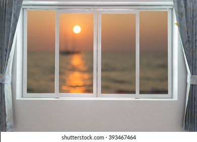 View Of Sunset On The Beach Through Window