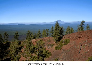 View of surrounding Cascade Mountain Range in the background as seen from the top of a lava butte, with the massive blanket of lava still covering the landscape. - Powered by Shutterstock