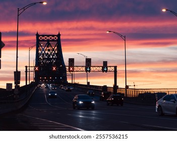 view of a suspended metal bridge on a colourful sunset with cars driving down - Powered by Shutterstock