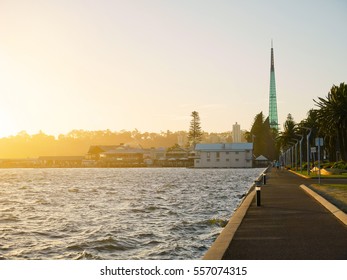 View of Swan River and walkway with Swan Bells on background in evening in Perth, Western Australia