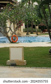 View Of Swimming Pool At Luxury Resort With Grass And Trees In Background. For Tourism Destination Concept. No People.