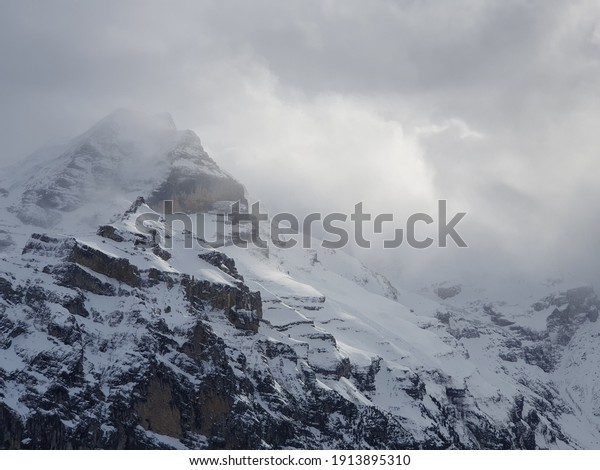 View of the Swiss mountains in winter. Eiger\
in clouds, Monoch and Jungfrau. Swiss alps in Jungfrauregion in\
Switzerland