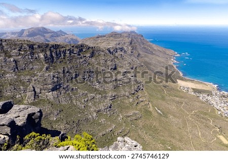 A view from Table Mountain of the mountaintops with clouds and the skyline in Cape Town, South Africa.