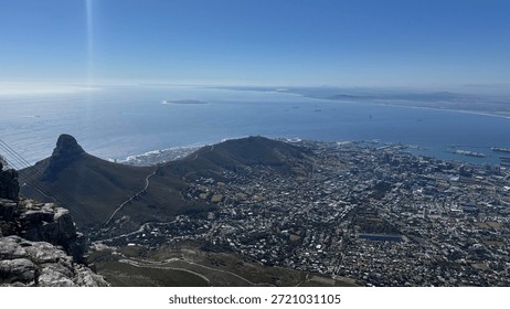 View Table Mountain overlooking Cape Town and the Atlantic coastline. Iconic South African landscape featuring city skyline, ocean, and natural scenery from a famous landmark.