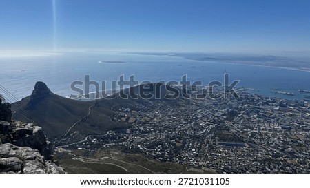 View Table Mountain overlooking Cape Town and the Atlantic coastline. Iconic South African landscape featuring city skyline, ocean, and natural scenery from a famous landmark.