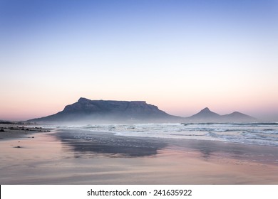 View of Table Mountain at sunrise, Cape Town, South Africa from Milnerton Beach coastline 