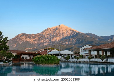 View of Takhtali Mountain reflected in the water of the hotel pool in Turkey, early morning at sunrise - Powered by Shutterstock