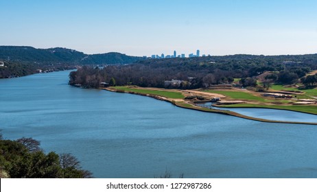 View from a tall hill of a river near Lake Travis with view of Austin skyline visible far away