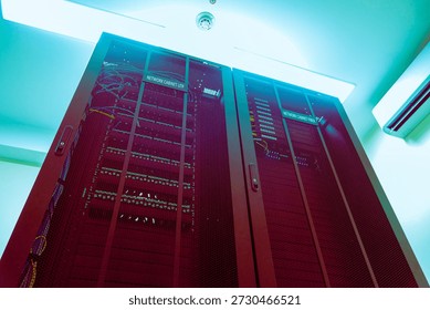 View of a tall server rack in a data center, showcasing networking equipment and cables under soft ambient lighting, emphasizing modern technology and organization. - Powered by Shutterstock - Get 15% off with code: PIKWIZARD15