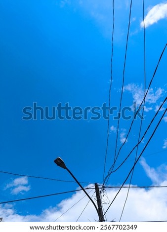 View of tangled messy cable over the tree and white cloud blue sky background