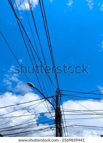 View of tangled messy cable with white cloud and blue sky background