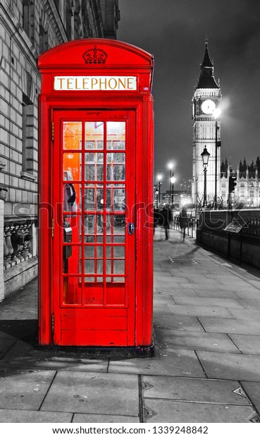 View of the Telephone Box and Houses of Parliament\
in London at night.